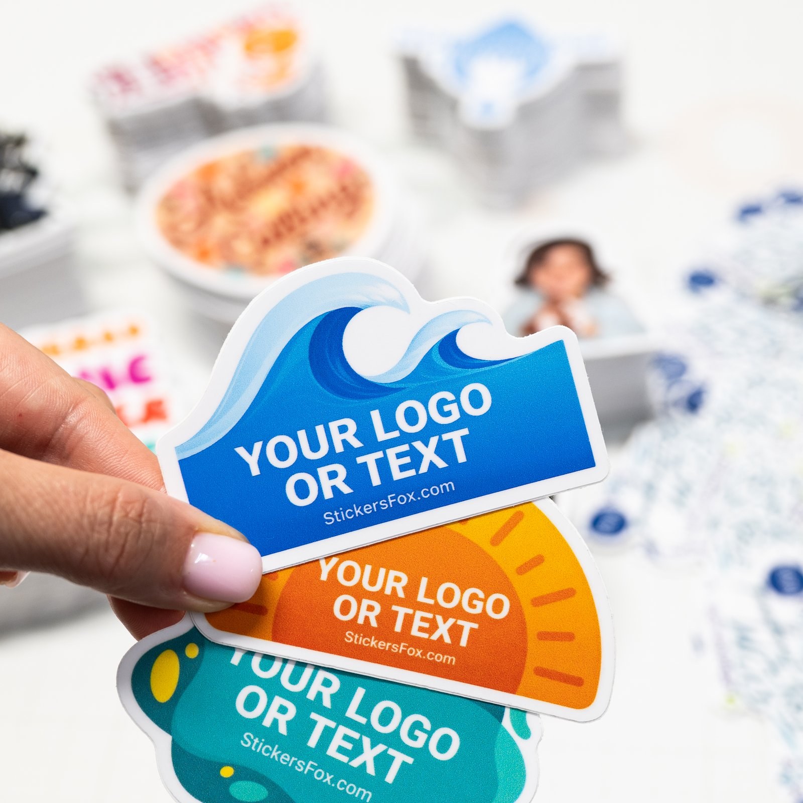 Custom die-cut stickers in assorted colors fanned out in hand