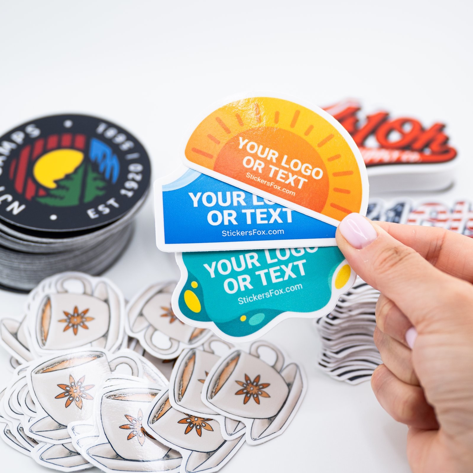 Custom printed die-cut stickers fanned out in hand